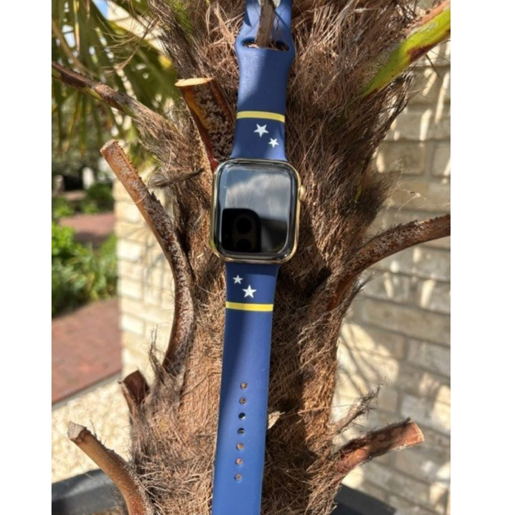 Curaçao Apple Watch bandje van BNationX bevestigd aan een palmboom in tropische sfeer. Blauw silicone smartwatch bandje met gele strepen en witte sterren, geïnspireerd op de vlag van Curaçao.