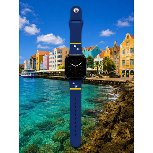 Blauw Curaçao Apple Watch bandje van BNationX met gele strepen en witte sterren, geïnspireerd op de vlag van Curaçao. Silicone smartwatch band met zwart horloge voor supporters en eilandliefhebbers, afgebeeld bij de kleurrijke Handelskade in Willemstad.