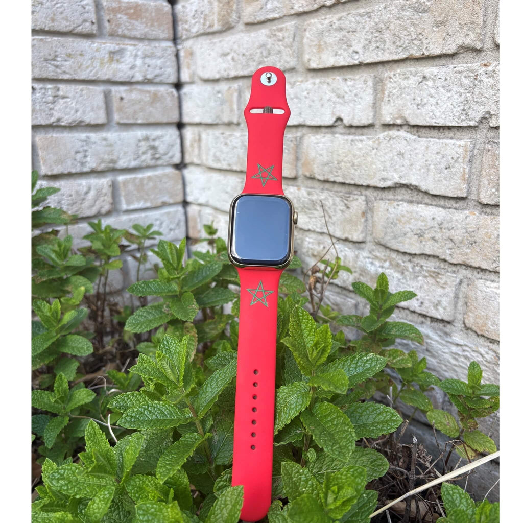 Marokko Apple Watch bandje van BNationX met rode silicone band en groene sterren, geïnspireerd op de Marokkaanse vlag. Smartwatch band afgebeeld in natuurlijke setting voor sportieve en stijlvolle looks.