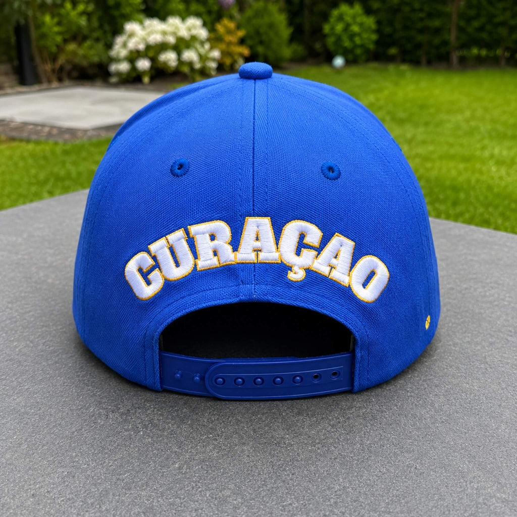 Achterkant van een blauw Curaçao supporterspetje van BNationX met geborduurd “CURAÇAO” logo en verstelbare sluiting. Sportieve cap geïnspireerd op de Curaçaose vlag voor supporters en zomerse outfits.