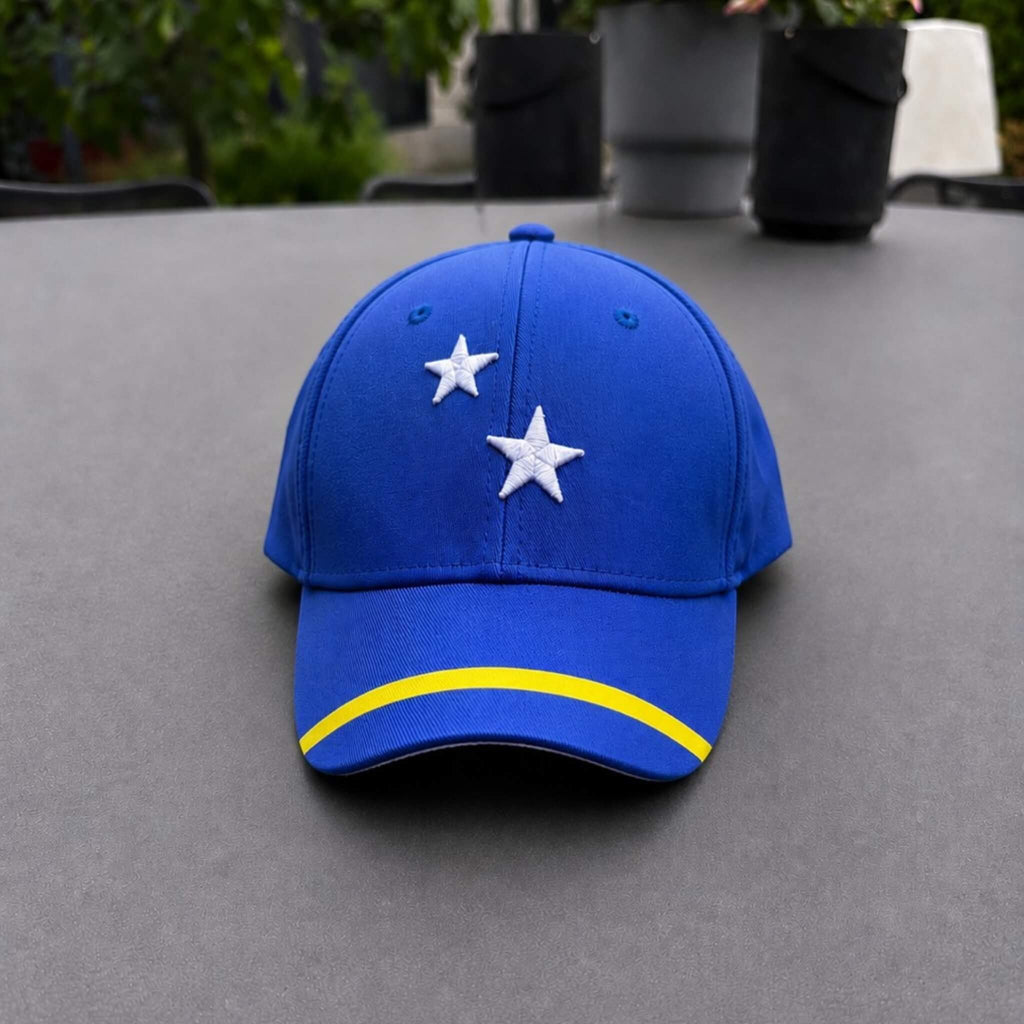 Blauw Curaçao supporterspetje van BNationX met witte sterren en gele streep, geïnspireerd op de vlag van Curaçao. Sportieve cap voor supporters, zomerse outfits en WK voetbal fans.