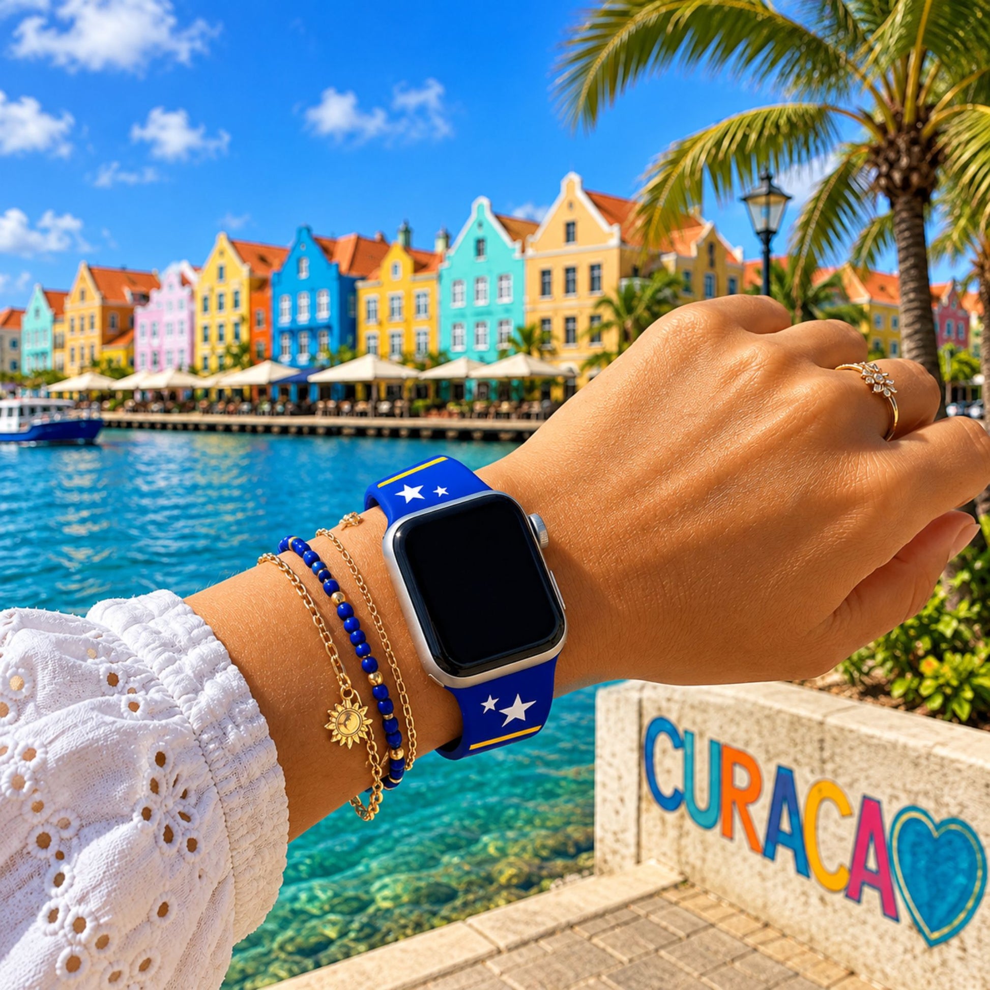 Curaçao Apple Watch horlogebandje van BnationX om de pols van een vrouw, met de kleurrijke kust van Curaçao op de achtergrond.